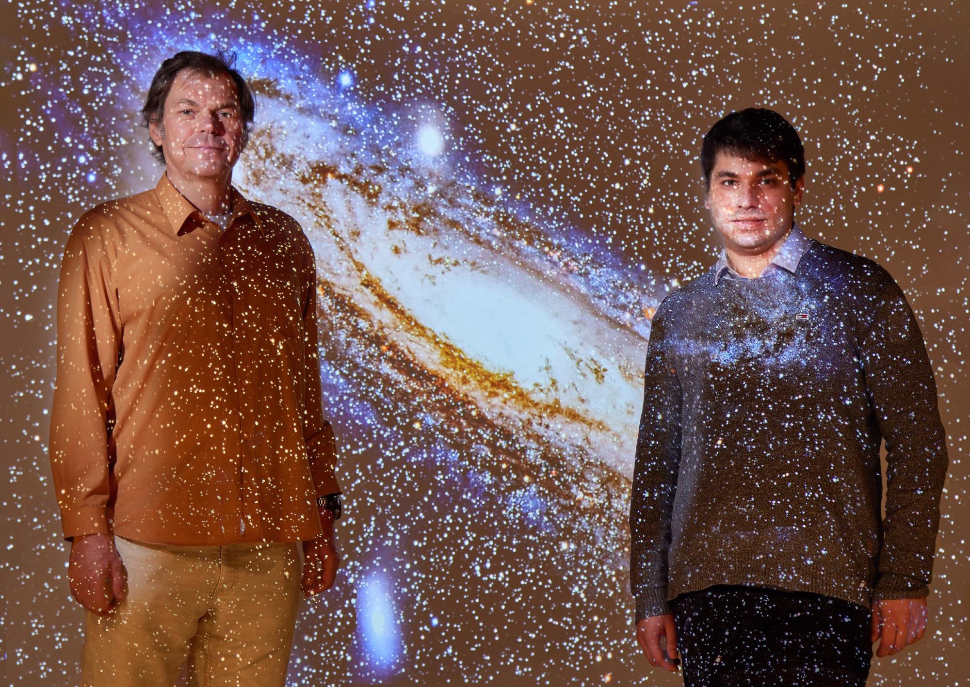 Prof. Dr. Pavel Kroupa (left) and Moritz Haslbauer (right) - with a projection of the Andromeda galaxy.